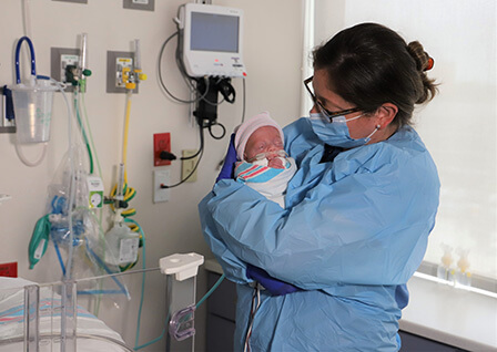 Nurse holding a baby in the Neonatal Intensive Care Unit