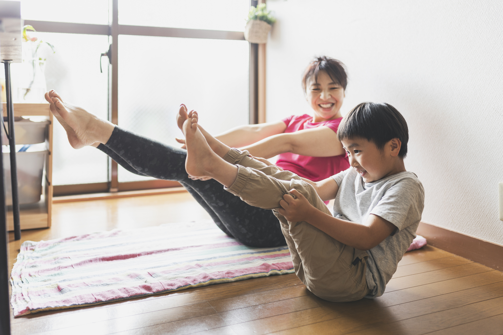 young buy and his mother doing yoga together