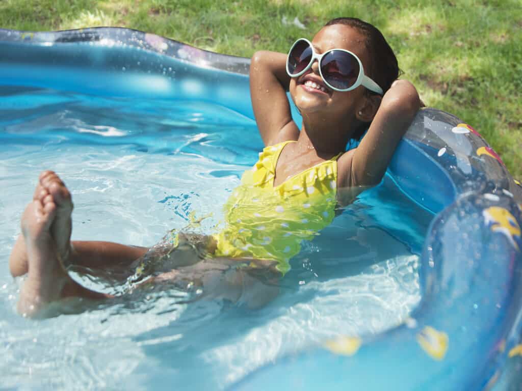 young girl in pool with yellow bathing suit
