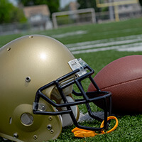 Football helmet and football on a grass field 