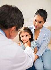 young girl being examined by doctor with mother