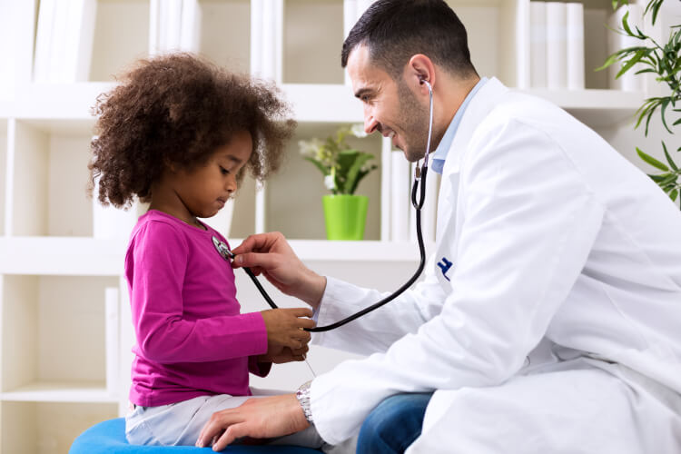 physician listening to child's heart with stethoscope 
