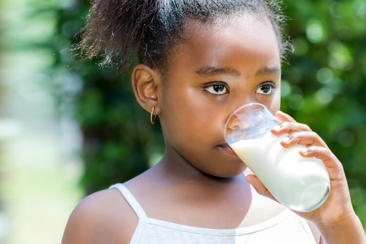 Little girl drinking milk outdoors